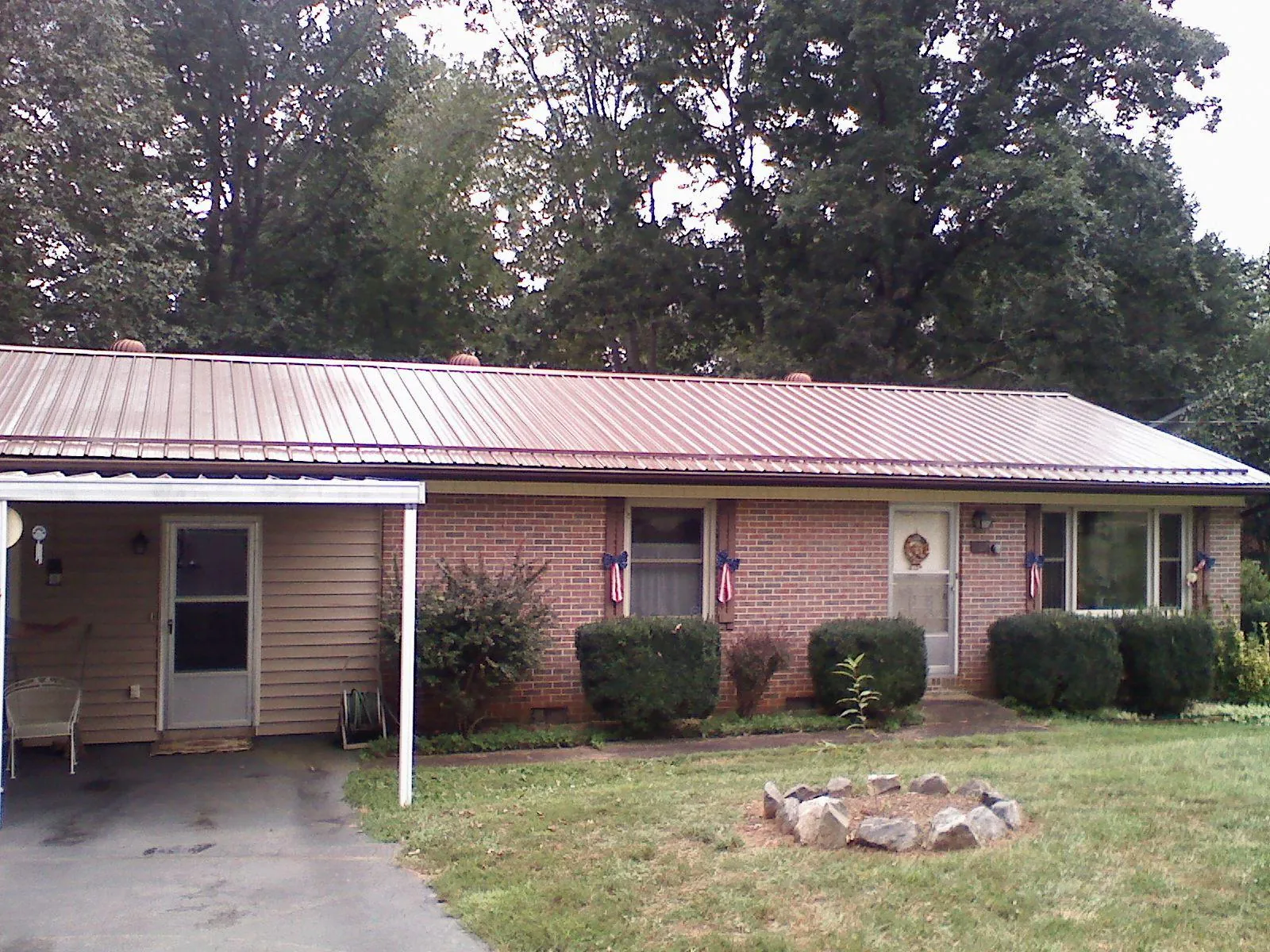 Bronze metal roof and carport on a brick ranch home — Roof Repair work by our crew in Hiltons
