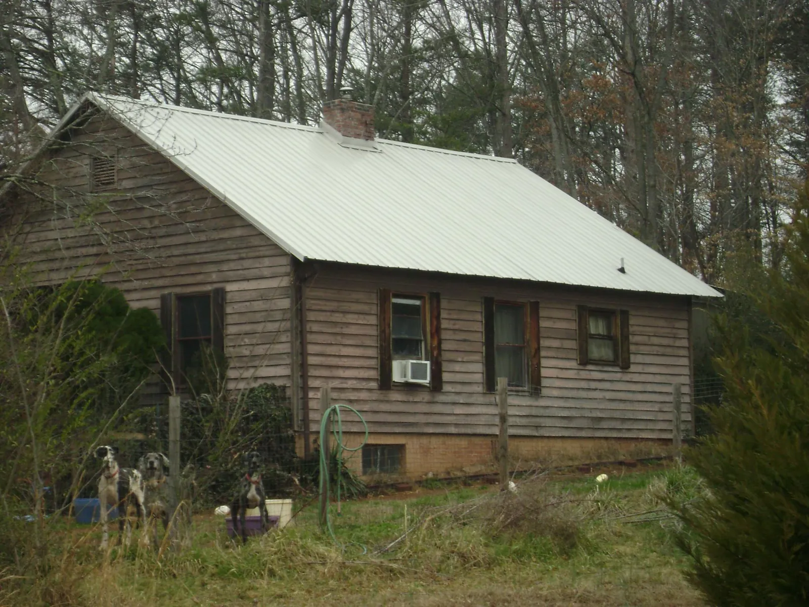 White metal roof on an old wood sided farmhouse, from a Metal Roof Installation job in Hiltons